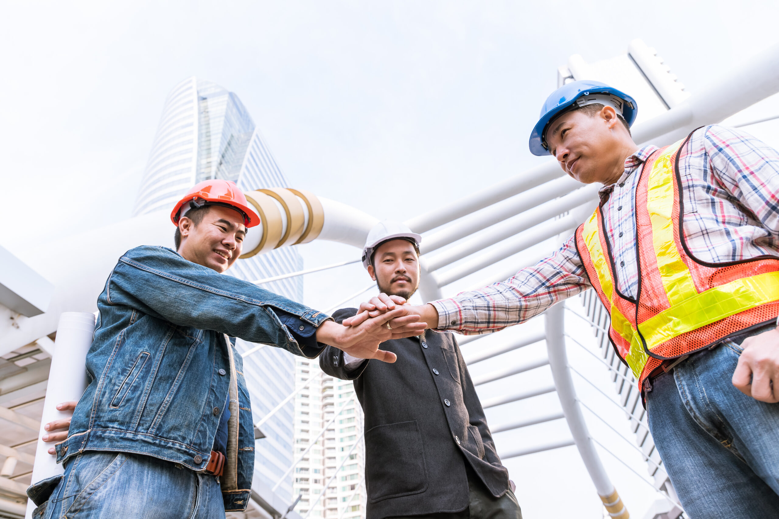 Manager meeting with engineer at outdoor site stack hand for teamwork